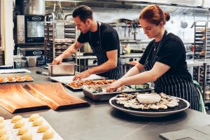 man and woman meal prepping food for restaurant
