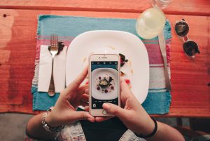 person taking picture of their food using mobile phone